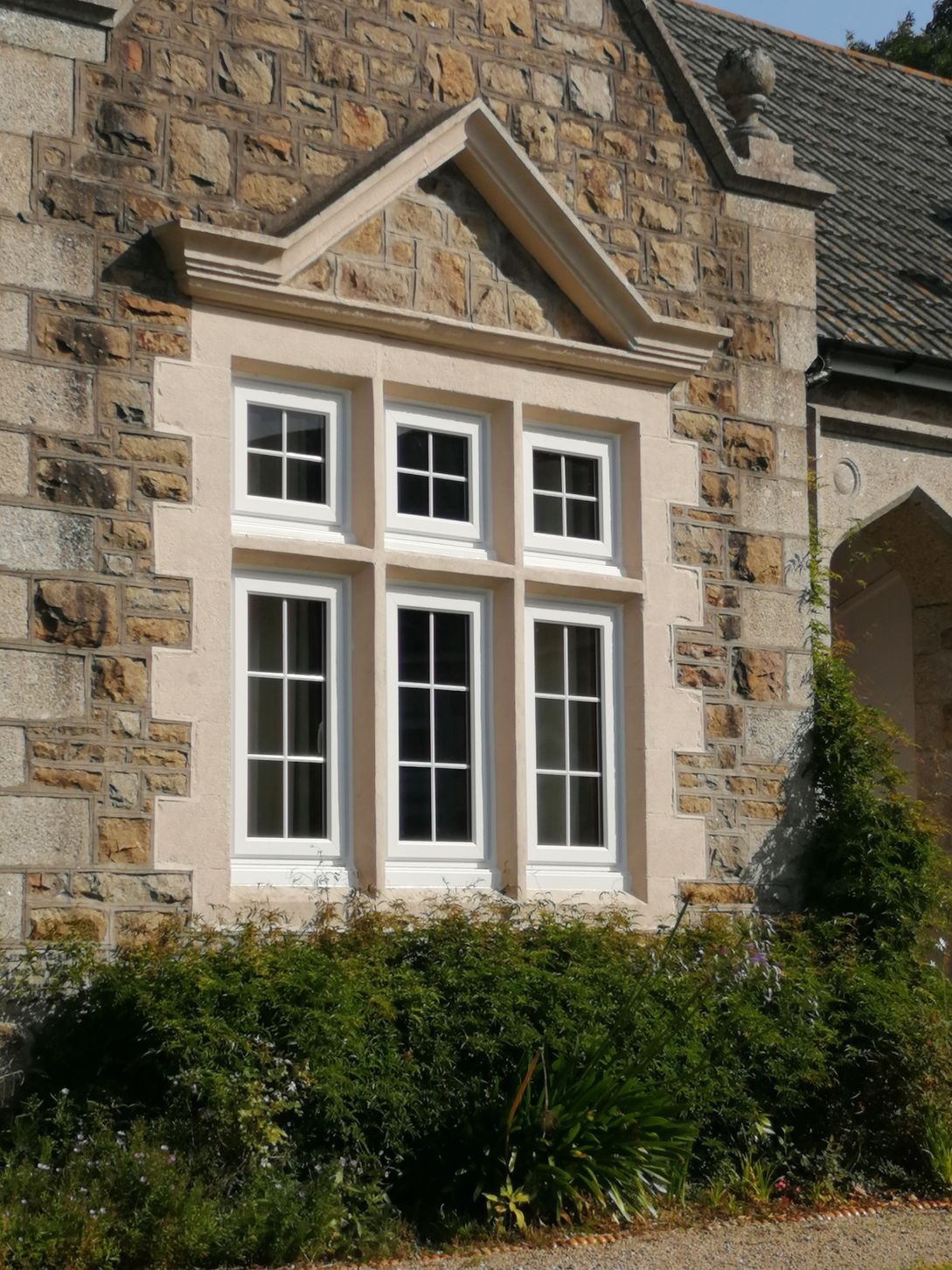 White PVCu windows into stone pillars